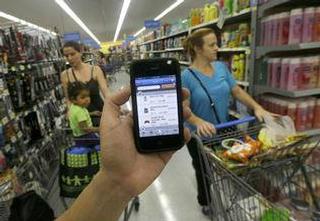 Un empleado de Wal-Mart muestra la aplicación descontinuada “Scan & Go” para celulares en un establecimiento de San Jose, California. / Foto por: Jeff Chiu / AP