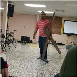 Alfonso Pena líder de Wake up Now en Puerto Rico enseñando la cruz donde estaría clavando a las alegadas victimas del esquema. / Foto por: Suministrada Facebook
